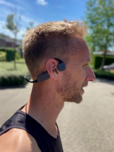 Mandlig l&oslash;ber med bone-conduction-hovedtelefoner