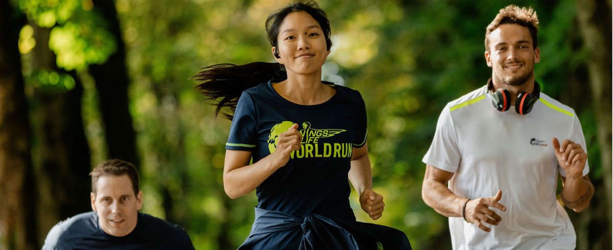 Tre Wings for Life World Run-deltagere l&oslash;ber med gl&aelig;de og har Philips-sportshovedtelefoner p&aring;.